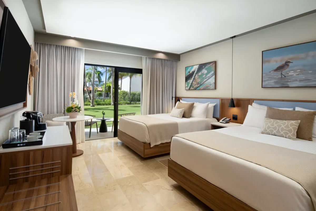 Deluxe Garden View room with two queen beds and private terrace at Hyatt Vivid Punta Cana overlooking lush gardens.